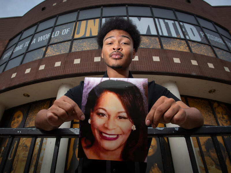 A photo of a man holding a photo of a woman's face. 