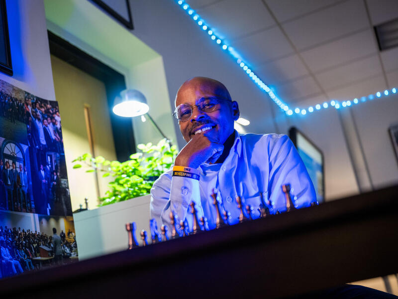 A man sits behind a chess board.