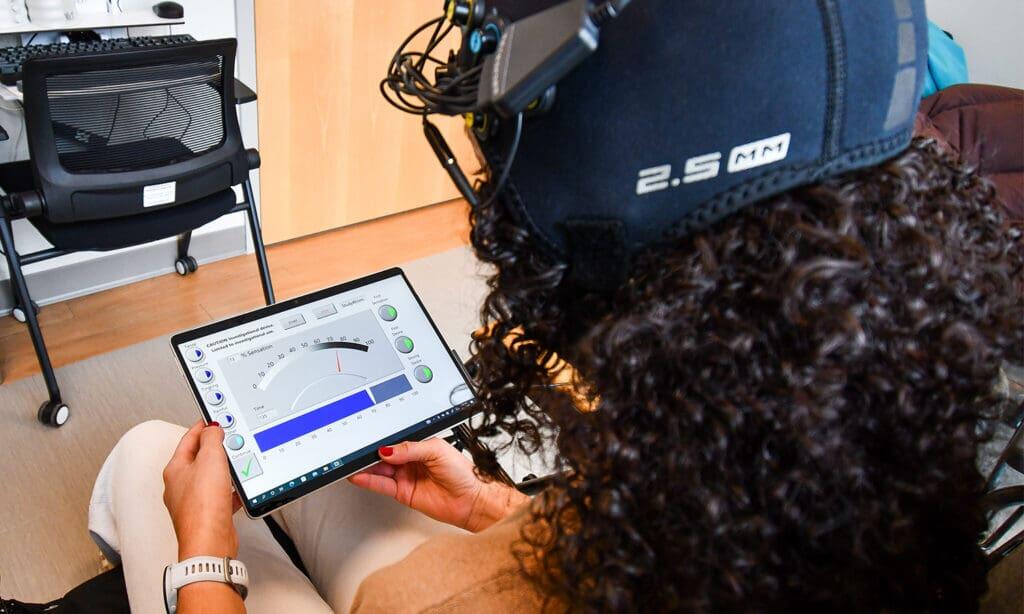 A photo of a woman looking at a tablet. 