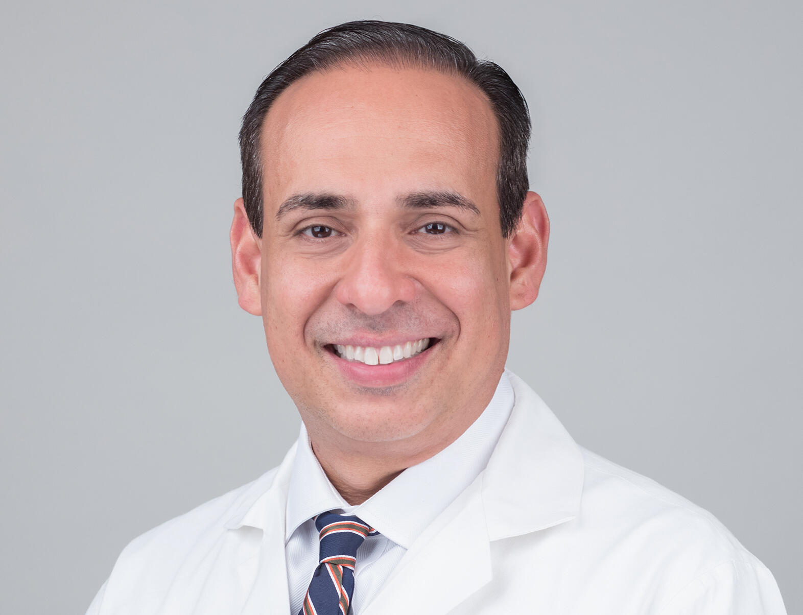 A man wearing a tie and a white lab coat