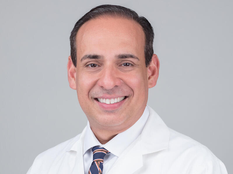 A man wearing a tie and a white lab coat