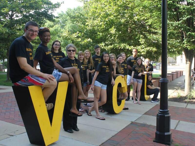A group of students and a faculty member pose for a photo arranged around the letters V-C-U.