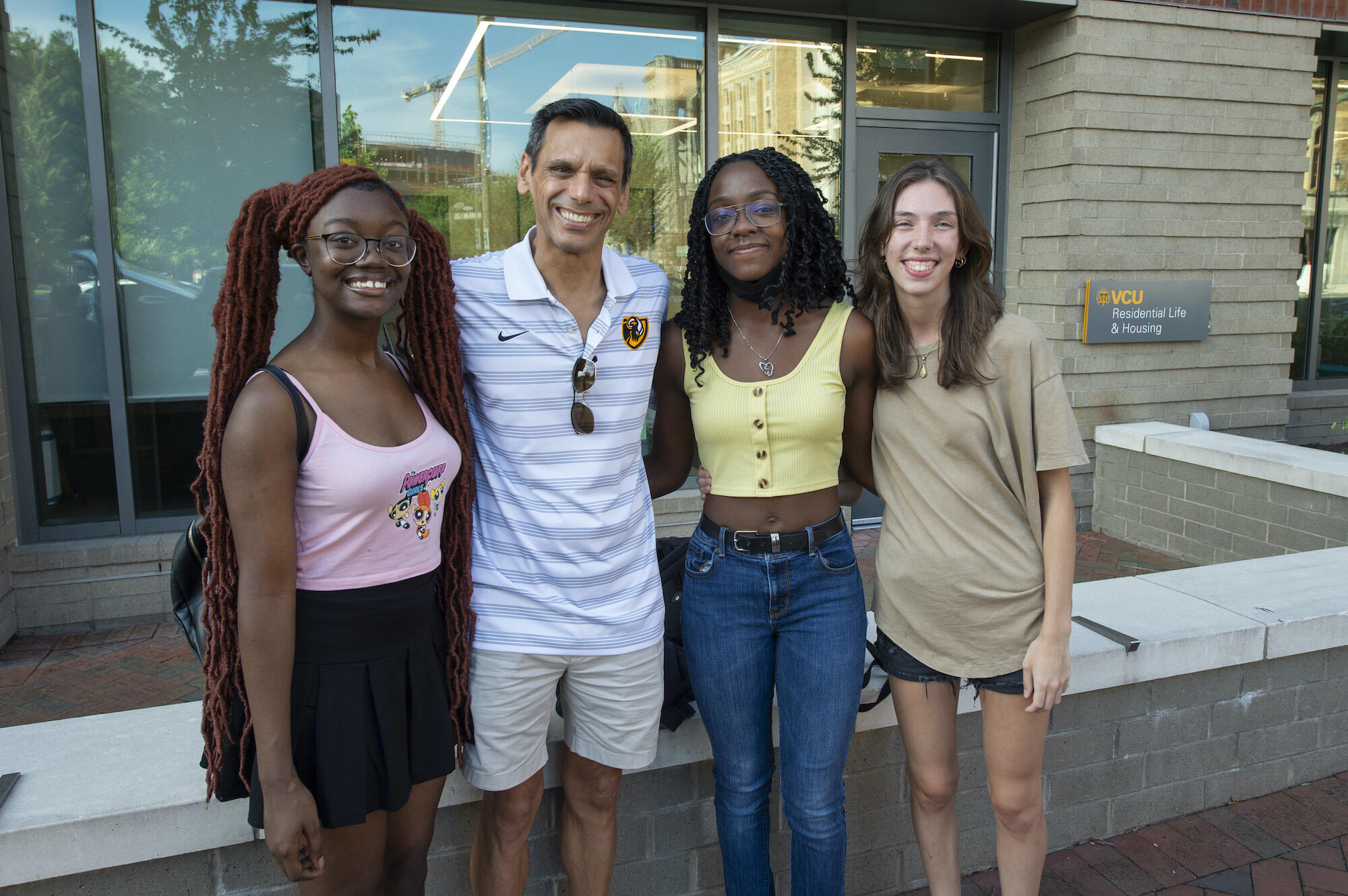 VCU President Michael Rao, Ph.D., with students Senaye Curry, Ebony Griffith and Lily Kirk. outside of Gladding Residence Center on Saturday. 