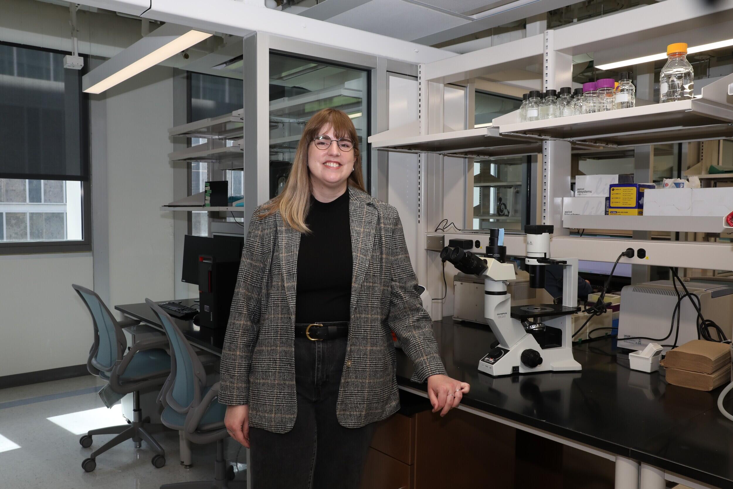 A photo of a woman standing next to a counter. 