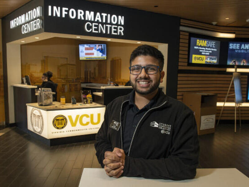 Smiling man in black coat with Student Commons and Activities VCU imprinted on it.