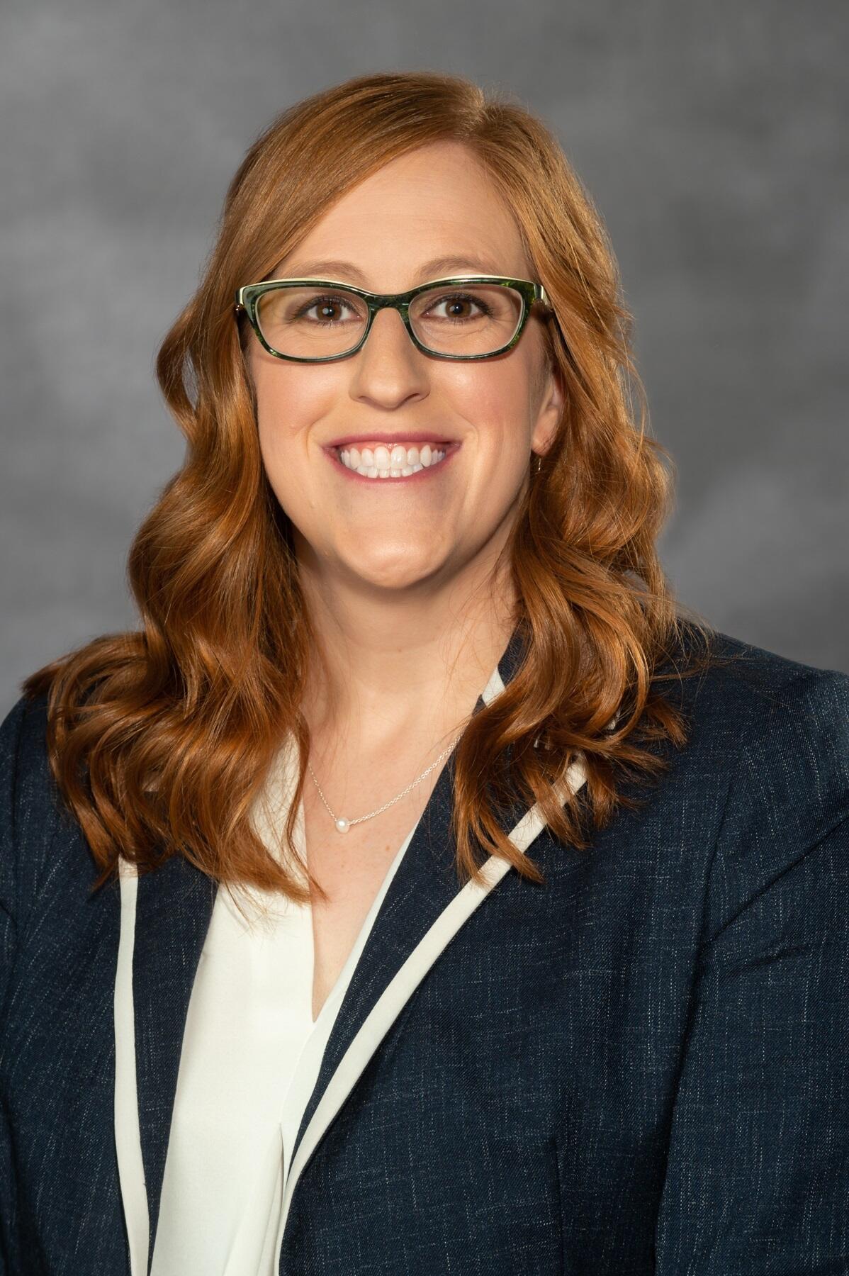 Amanda Goodson, Ph.D., wearing glasses and a sports quote while smiling at the camera