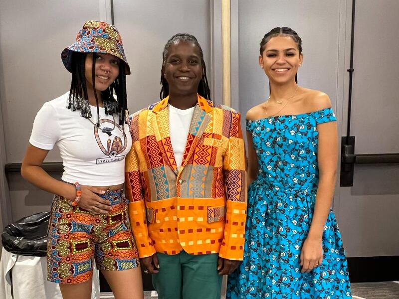 Three people standing next to each other. 