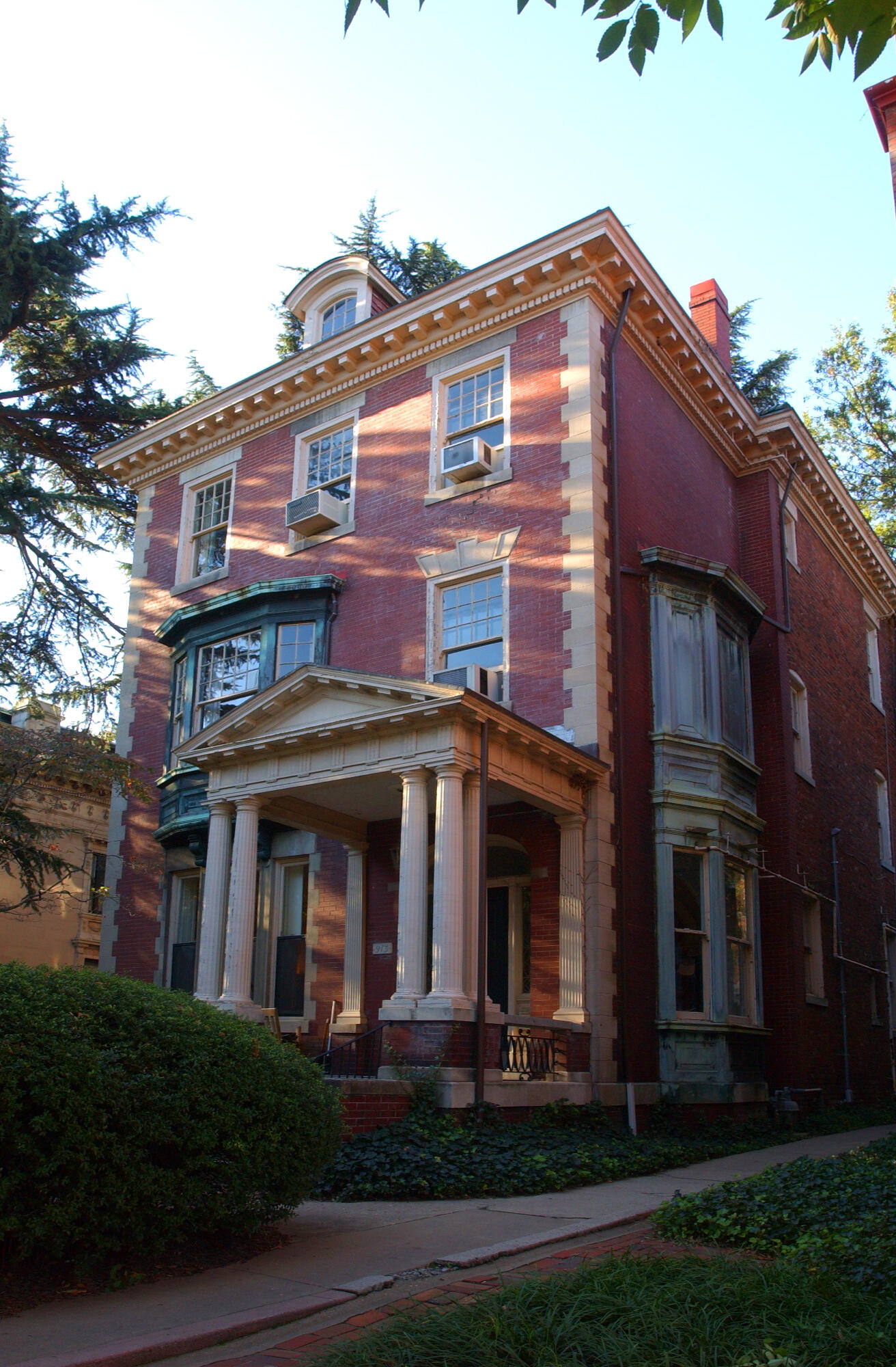 A photo of a three story brick house. 