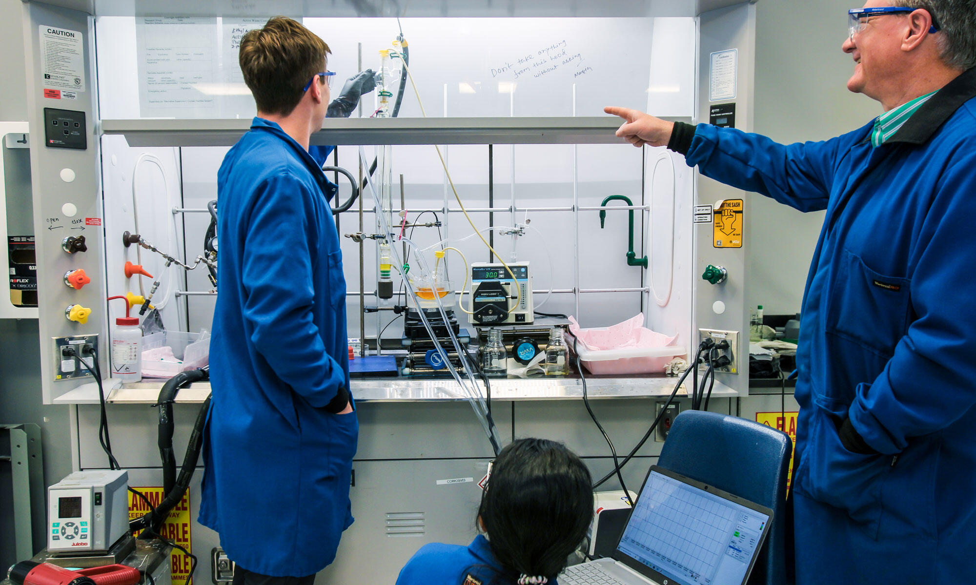 A photo of three people in a lab.