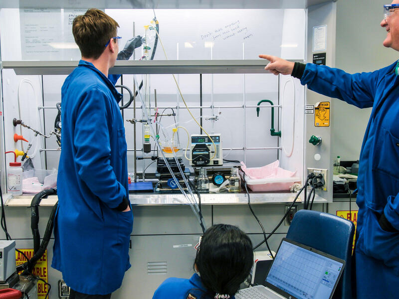 A photo of three people in a lab.