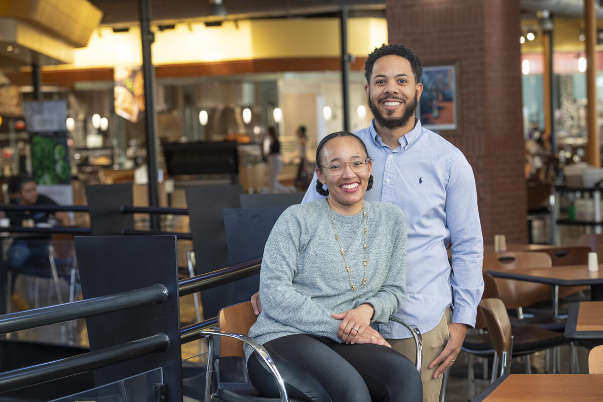 A woman wearing a gray long sleeve shirt sitting in front of a man wearing a blue button down shirt. 