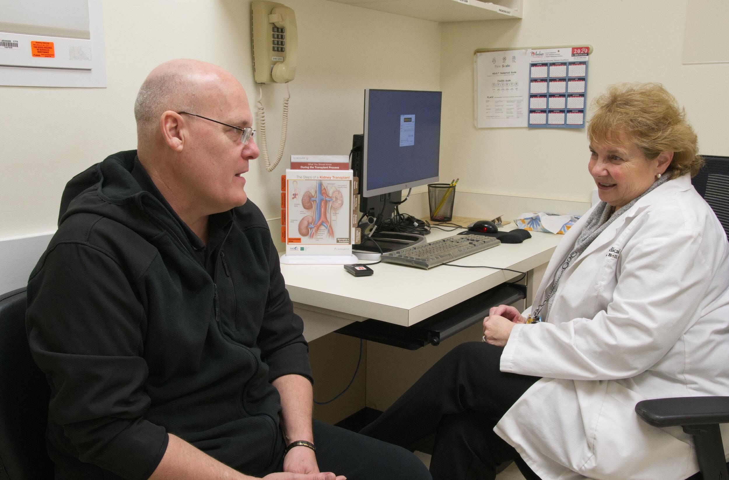 A patient and a health care coordinator in a patient room.