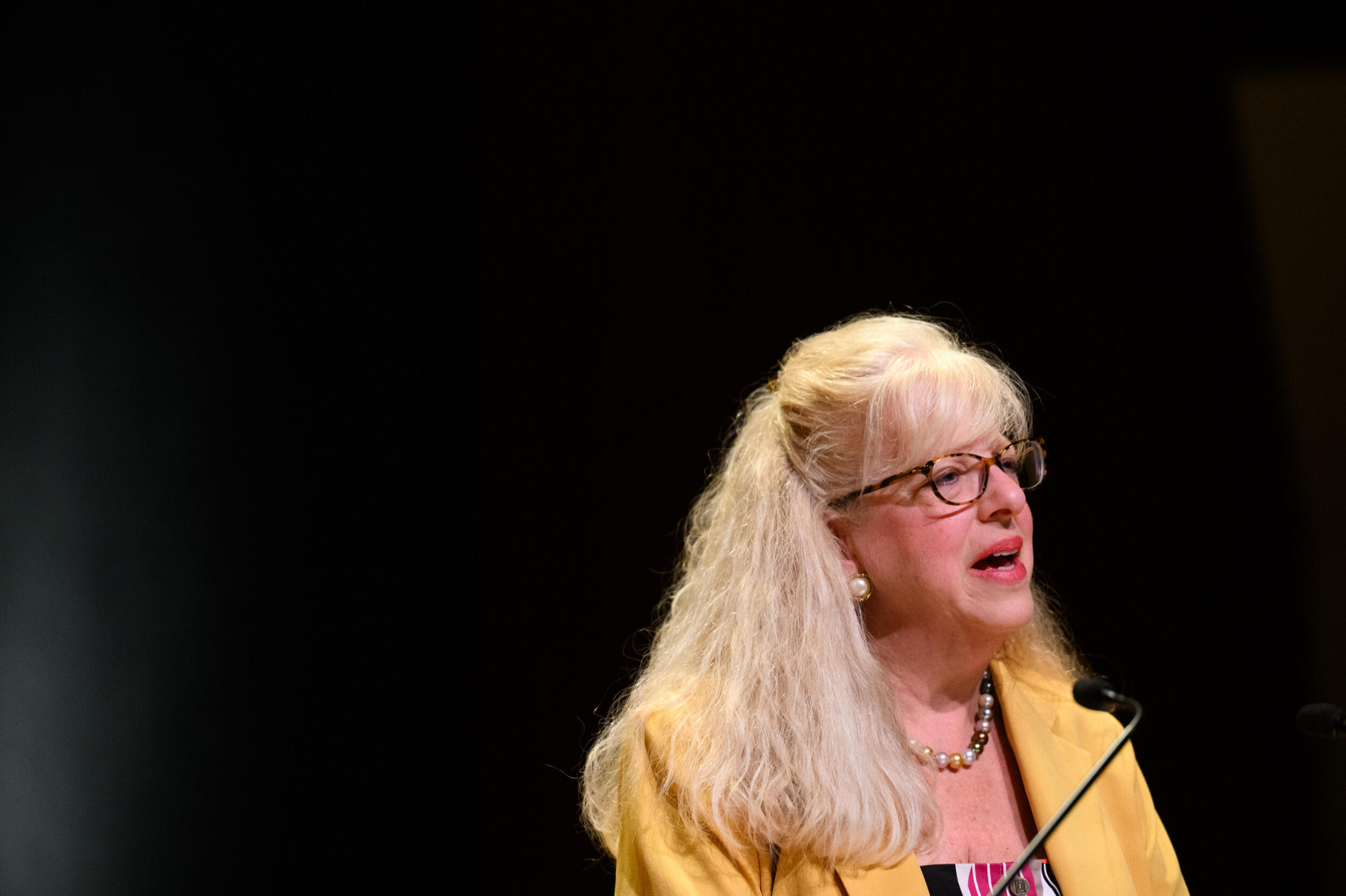 A woman speaks into a microphone.
