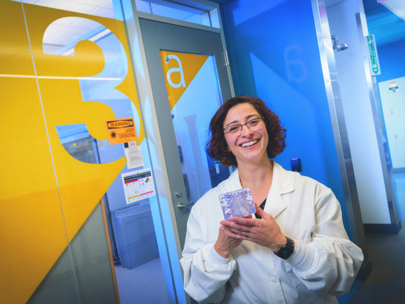 A photo of a woman wearing a white lab coat standing in a hallway 