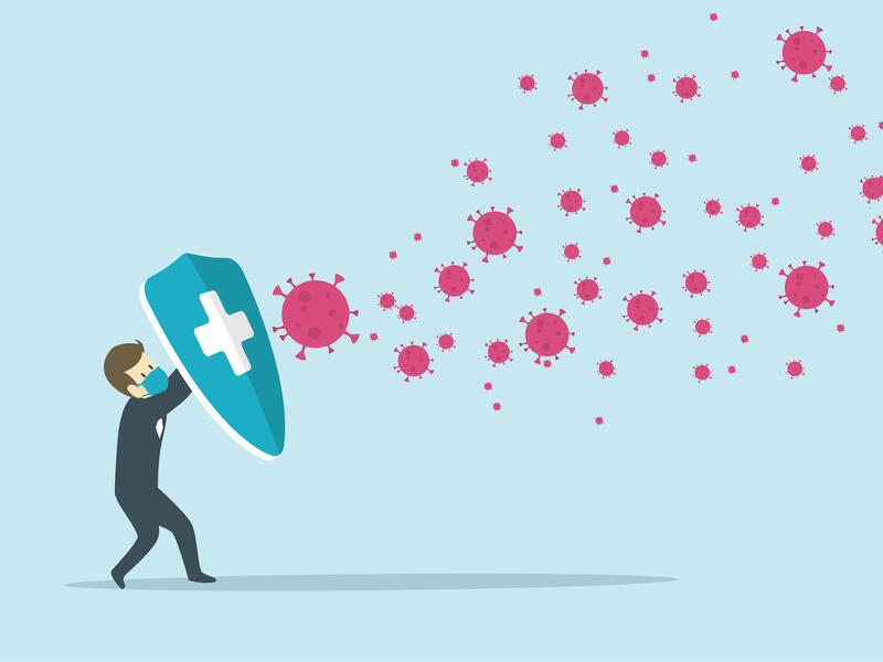 illustration of a man wearing a mask and holding a shield to block COVID particles