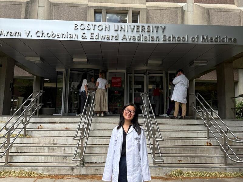 A photo of a woman standing in front of a building. 