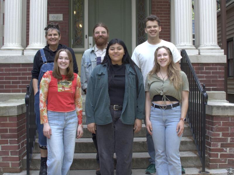 A photo of six people standing in front of the entrance to a building. 
