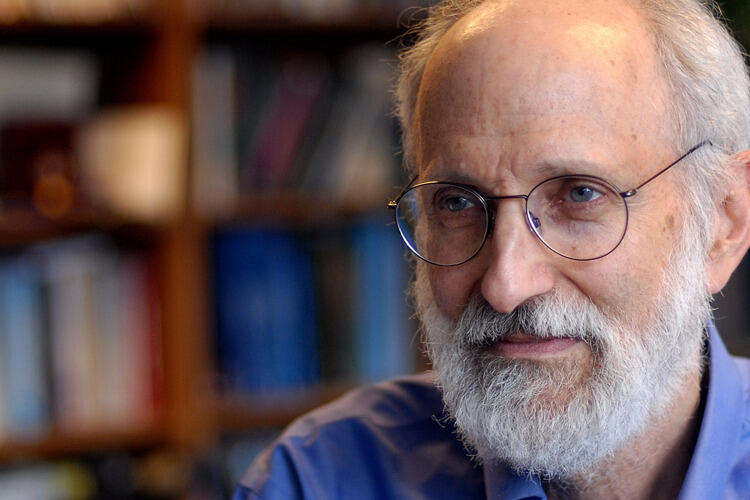 A photo of a man with white hair and a beard wearing glasses