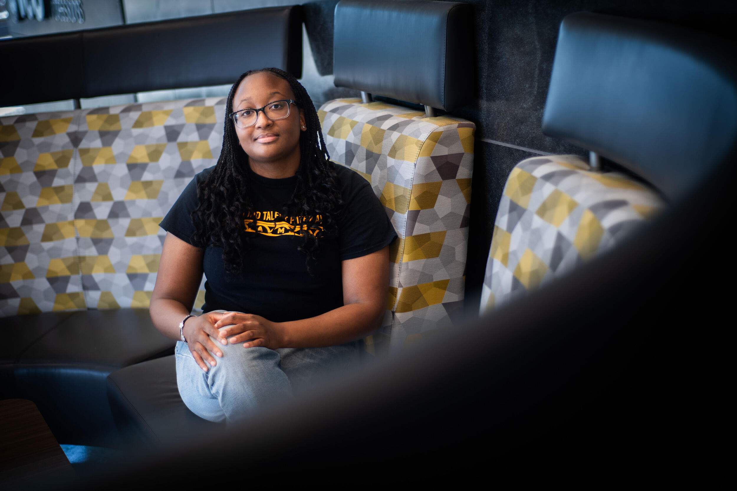 A photo of a woman sitting on a couch. 