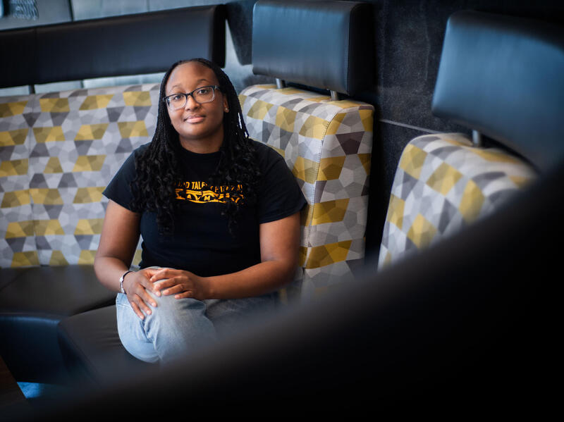 A photo of a woman sitting on a couch. 