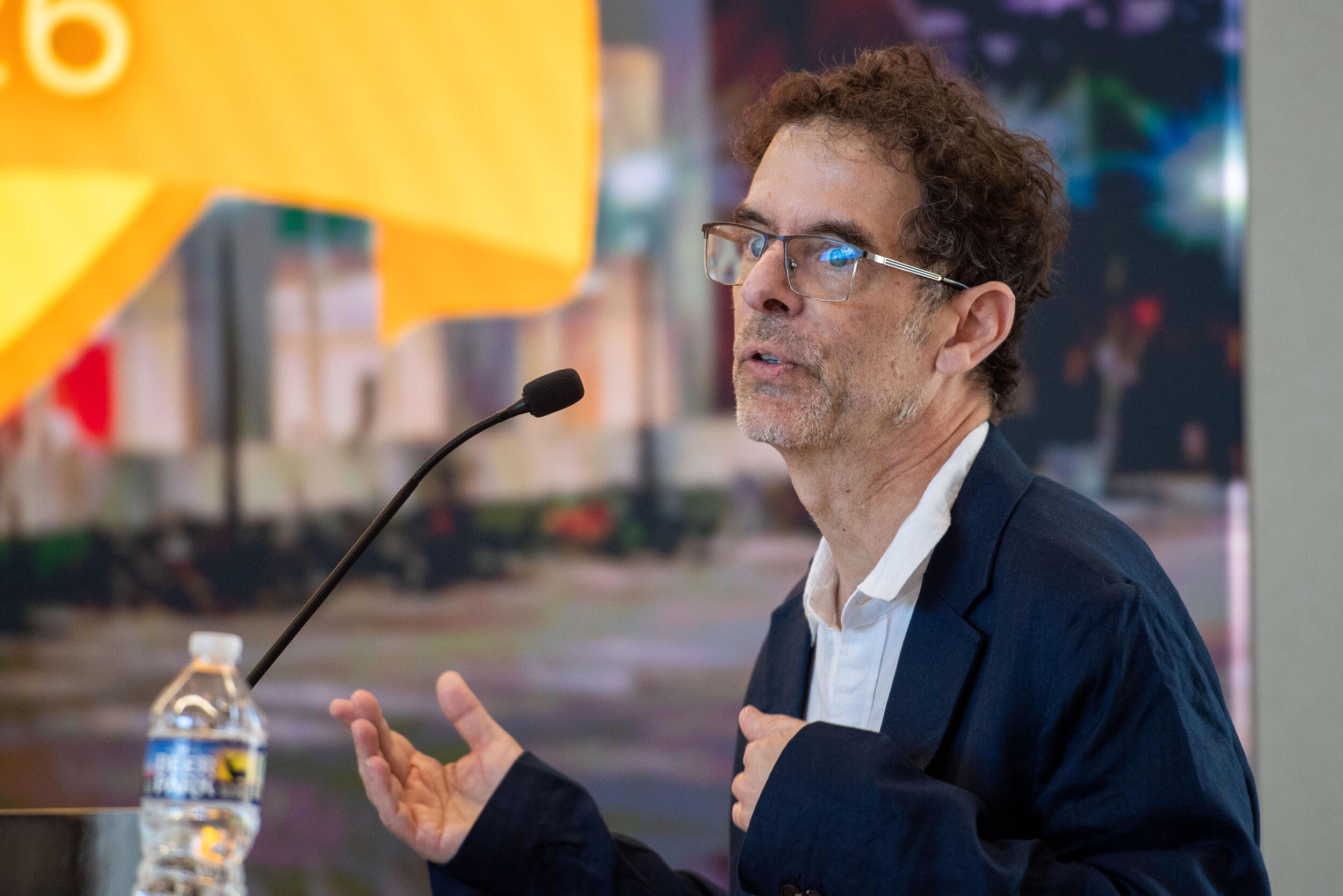 A photo of a man speaking behind a podium.
