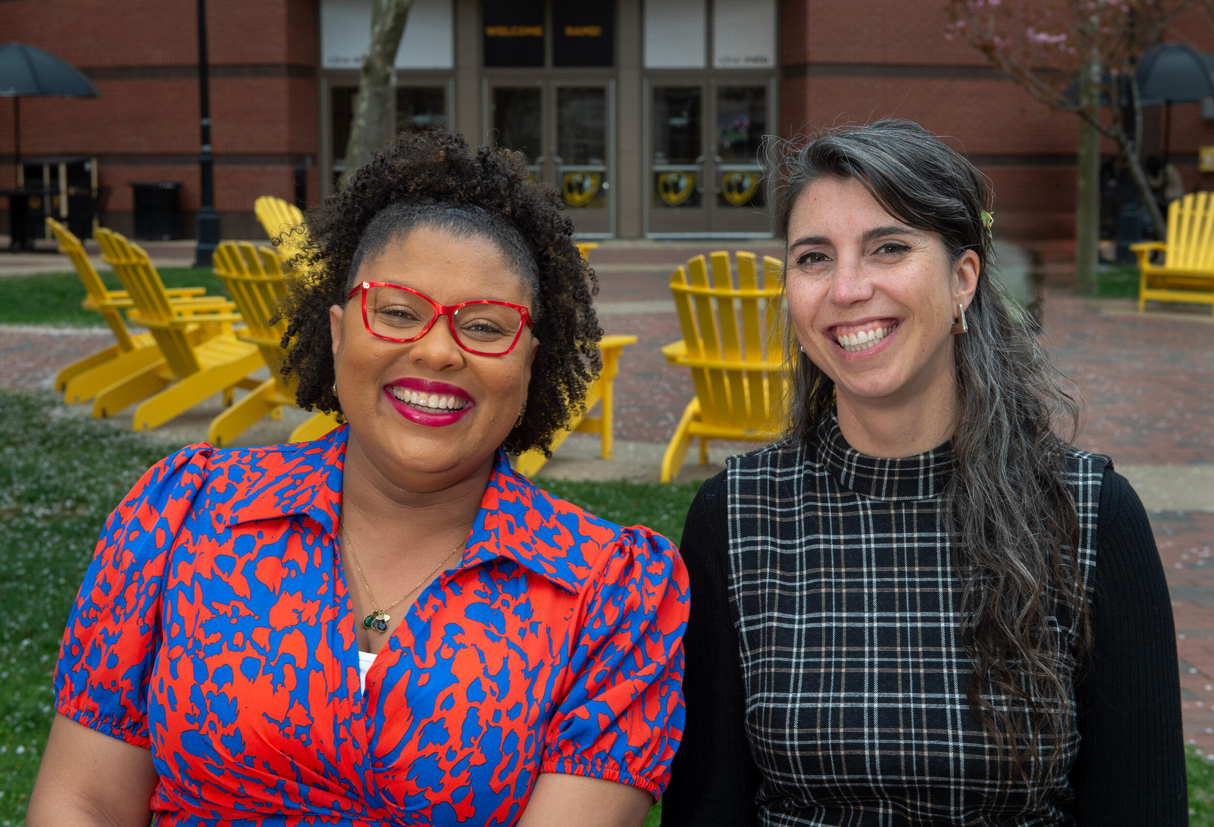 Two women smiling with Adirondack chairs in the background.