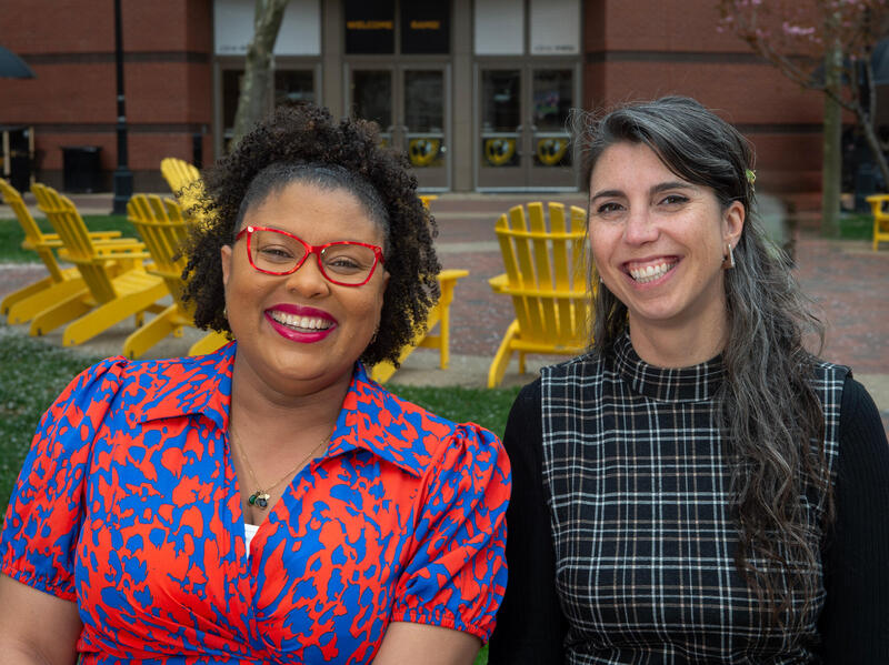 Two women smiling with Adirondack chairs in the background.