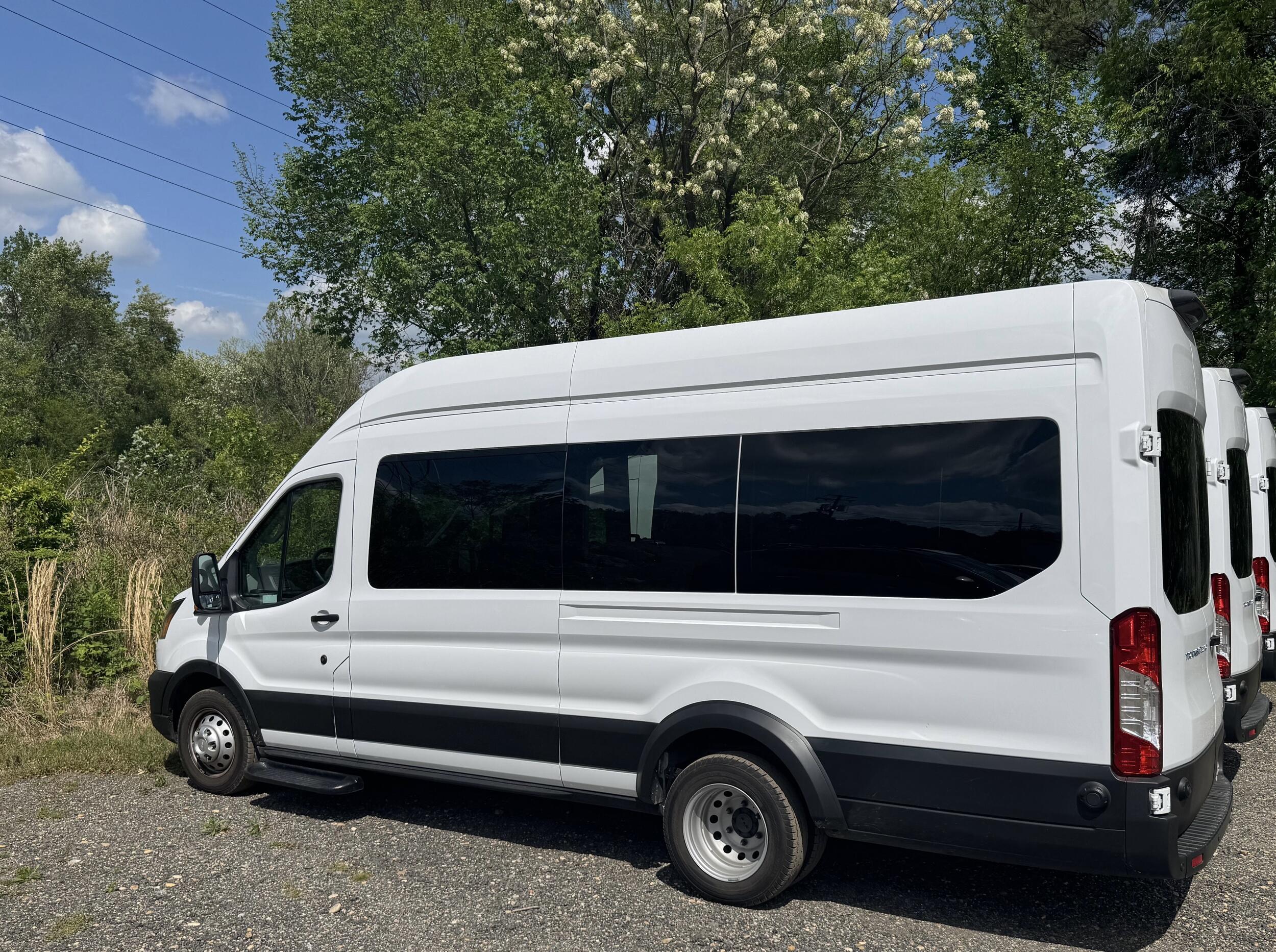 A photo of a row of three white vans. 