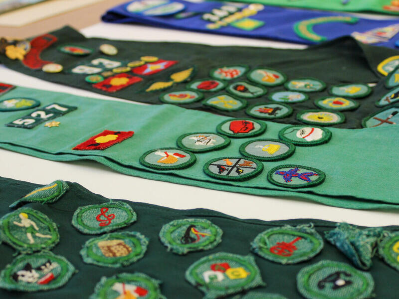 Four vests with circular patches sewn on them. 