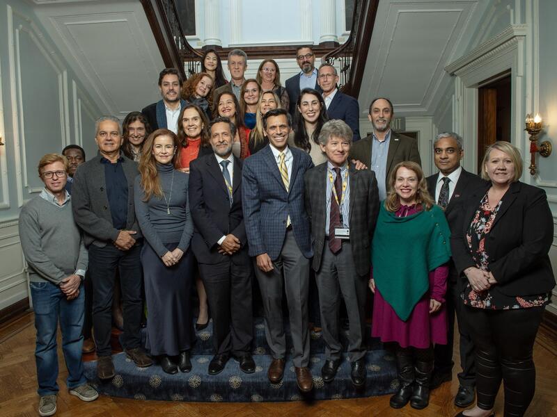 A group photo of 24 people standing on and around a staircase. 