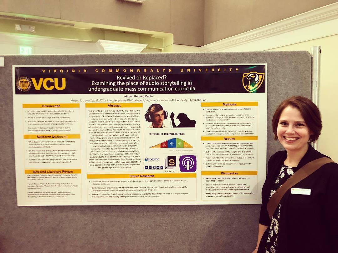 A woman standing to the right of a poster with research information on it. 