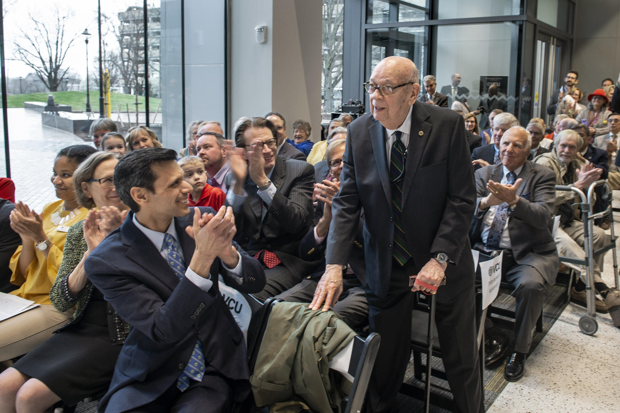 Thomas Barker, Ph.D., standing to be recognized by attendees of an event.