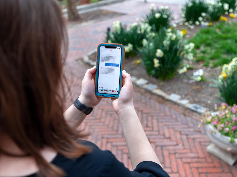 A person reads a text message on a cell phone.
