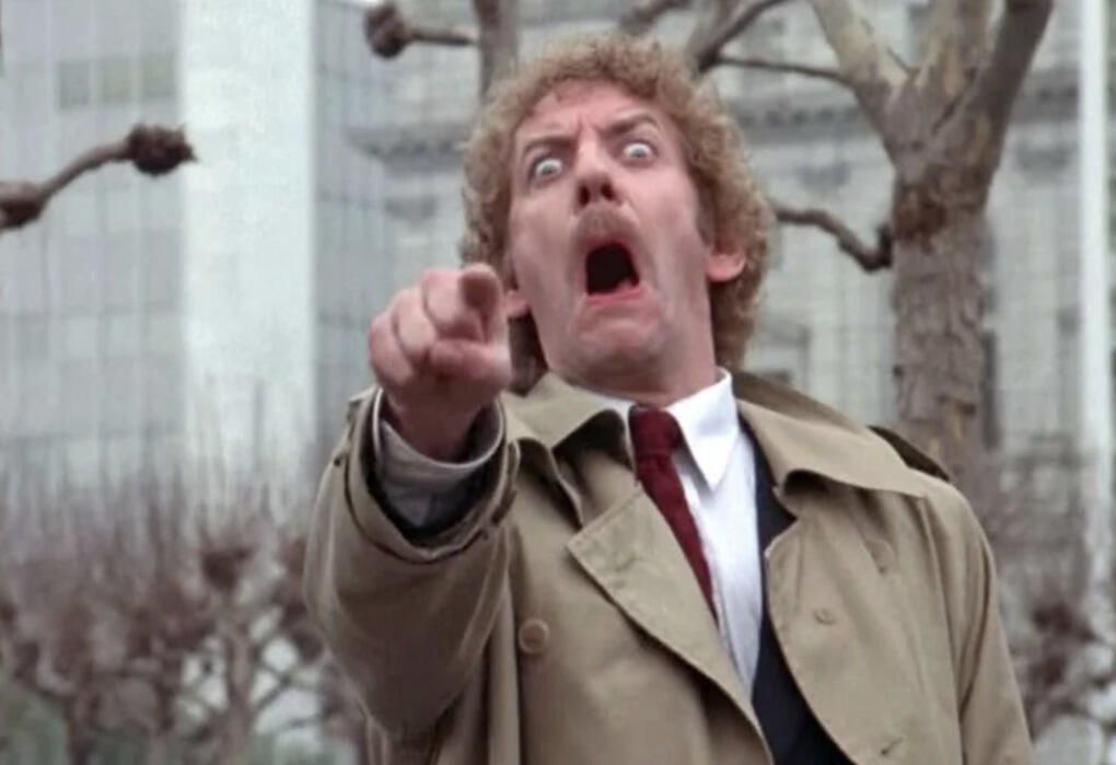 Man with eyes and mouth wide open pointing.