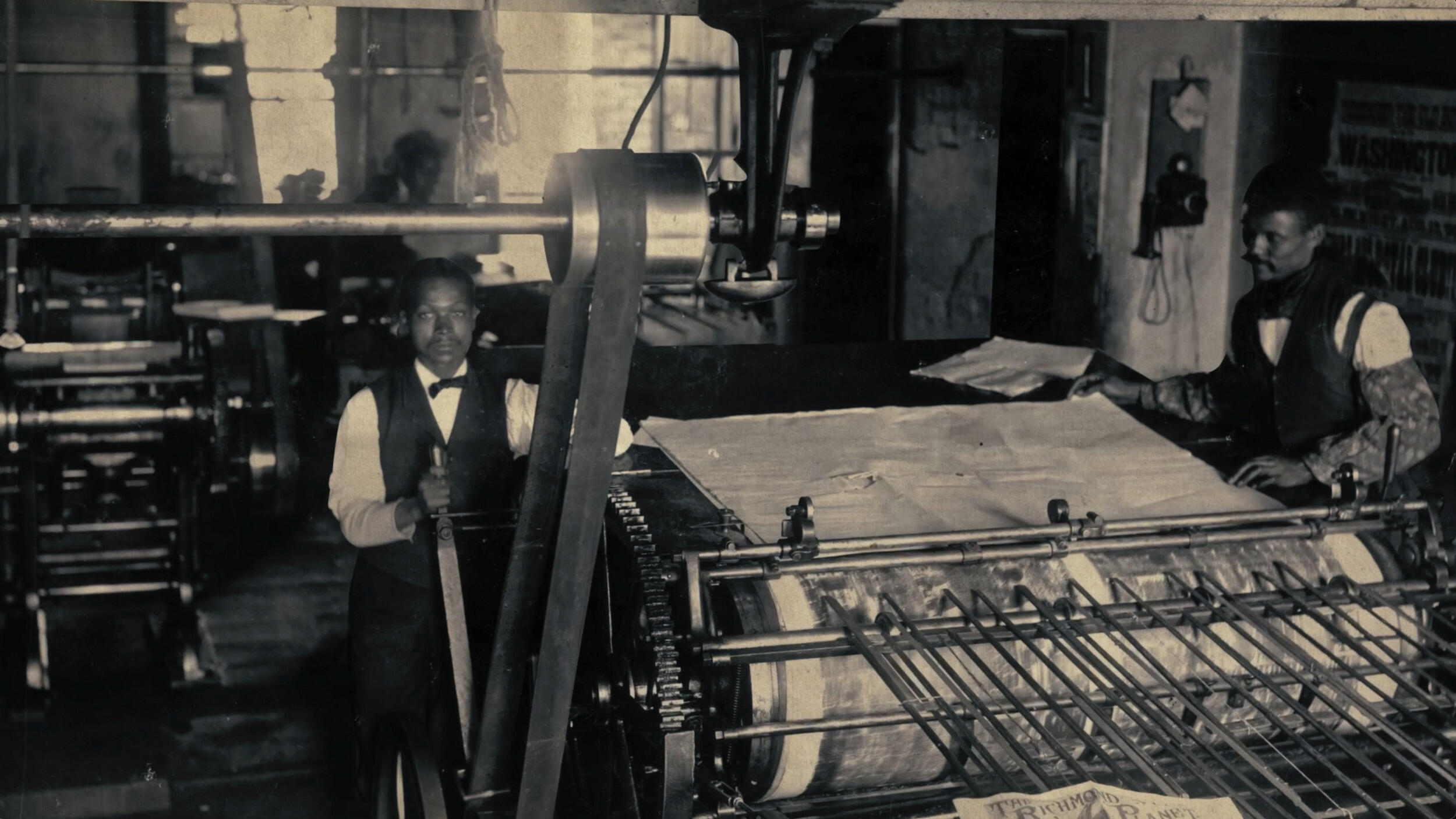 An old photo of two men next to industrial equipment 
