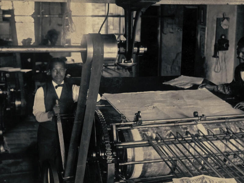 An old photo of two men next to industrial equipment 