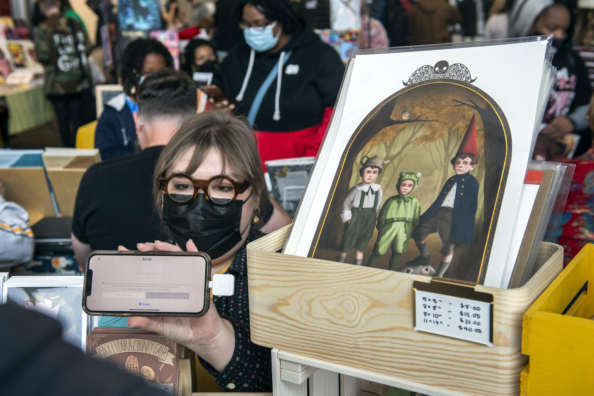 Abby Giuseppe works with a customer buying some of Giuseppe's art at the 2021 Richmond Indie Comic Expo