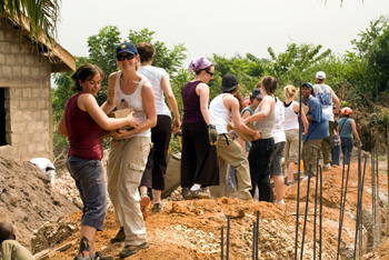 VCU School of Social Work students transfer concrete blocks for the construction of a child development center, which will serve as a home and school for street children and children living in the rural village of Adoteiman, Ghana.  The proceeds from last fall’s FOR AFRICA benefit helped to pay for the building materials and skilled labor necessary to build the center. Photo by Doug Buerlein. 