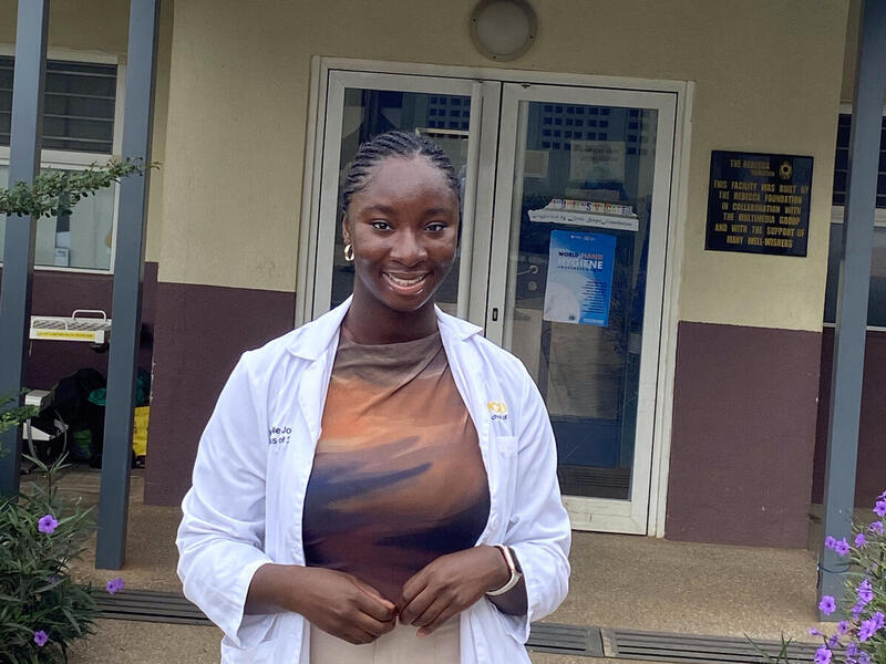 Woman standing in front of a hospital entrance.