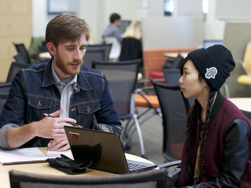 a student and a writing mentor work on a paper together