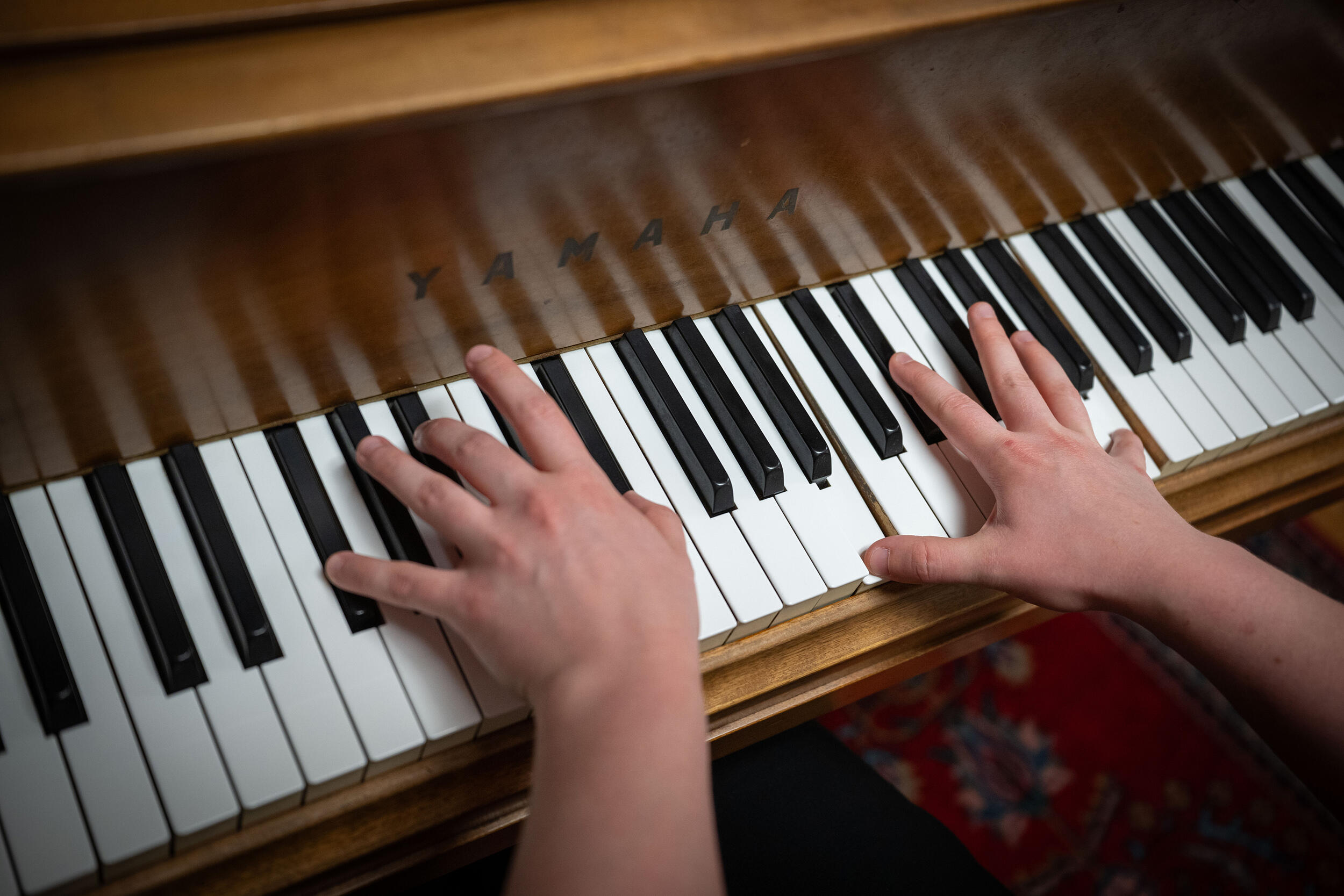 A photo of hands playing a piano 