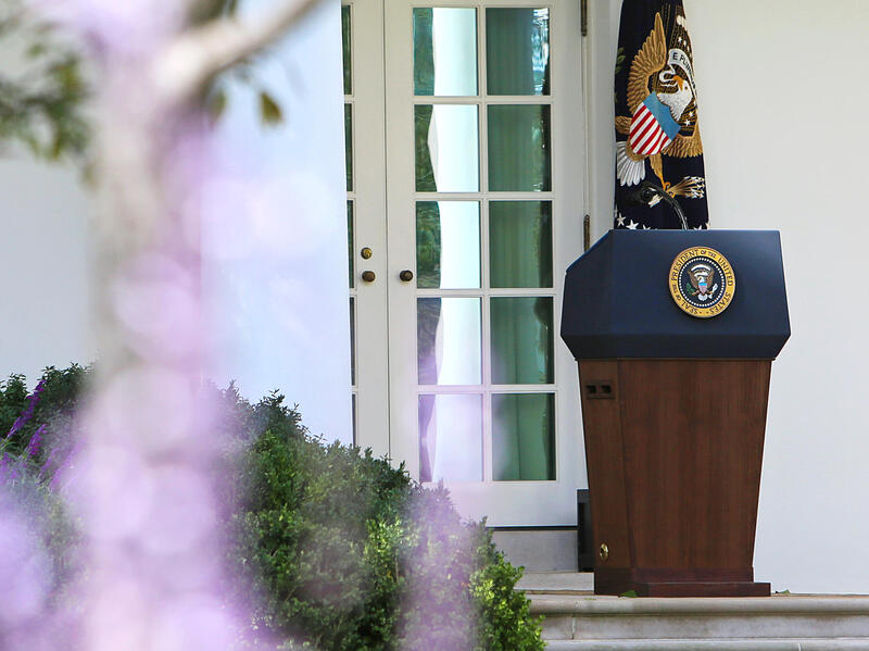 The press podium with the U.S. Presidential emblem on it. 