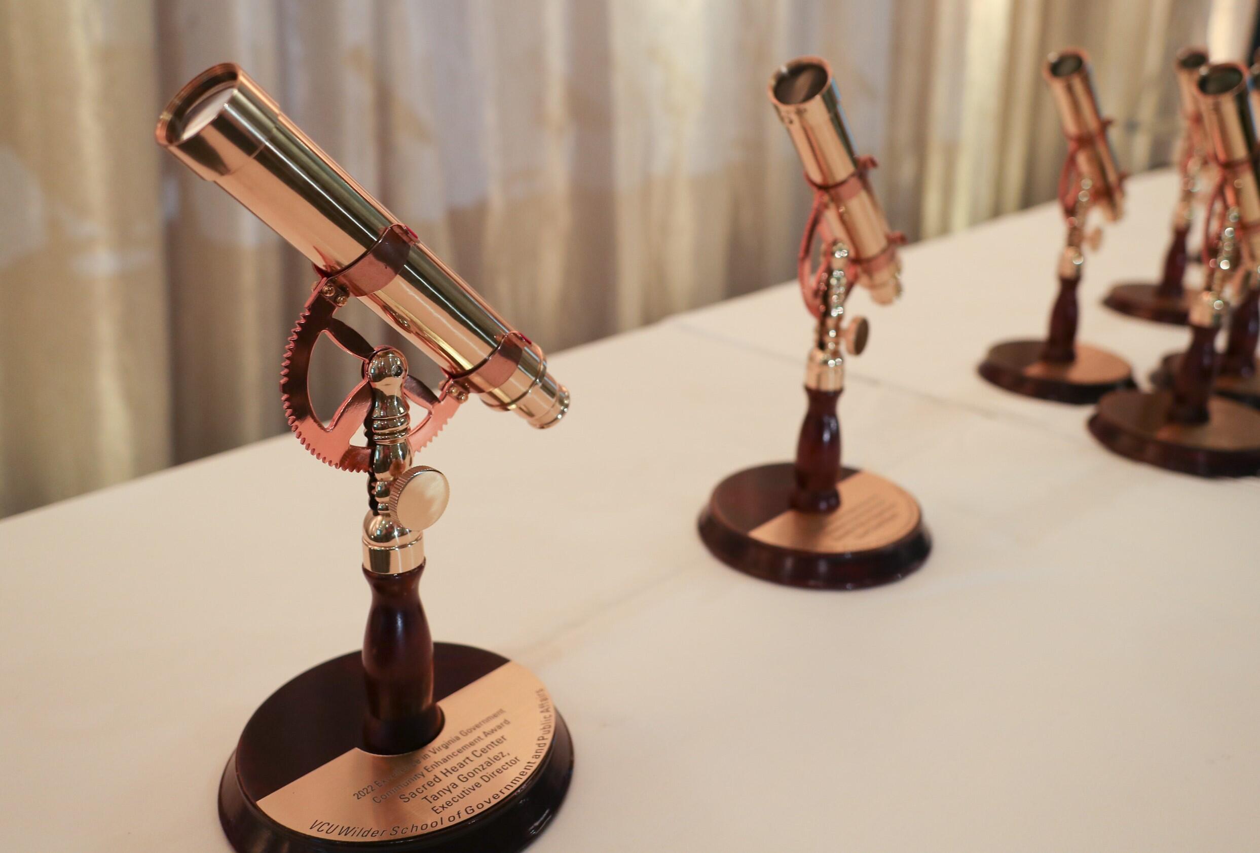 A photo of five awards that look like telescopes 