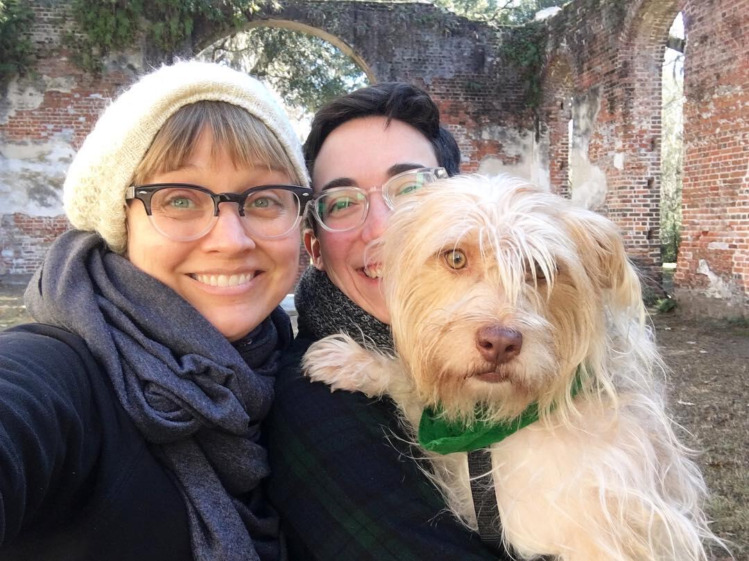 Two people holding a dog.