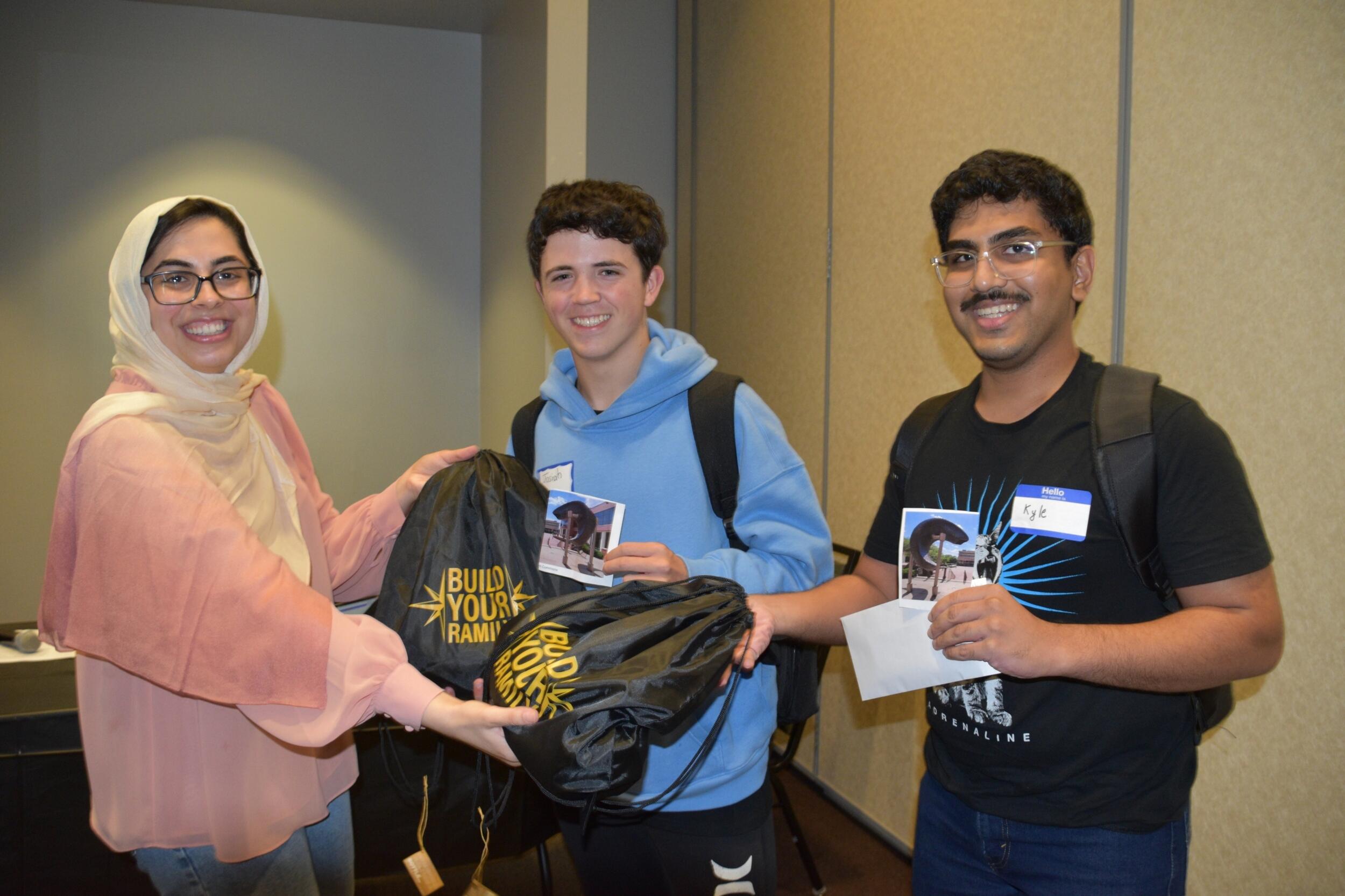 A group photo of three people from the waist up. 