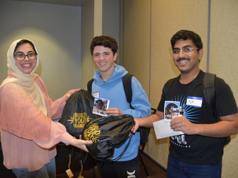A group photo of three people from the waist up. 