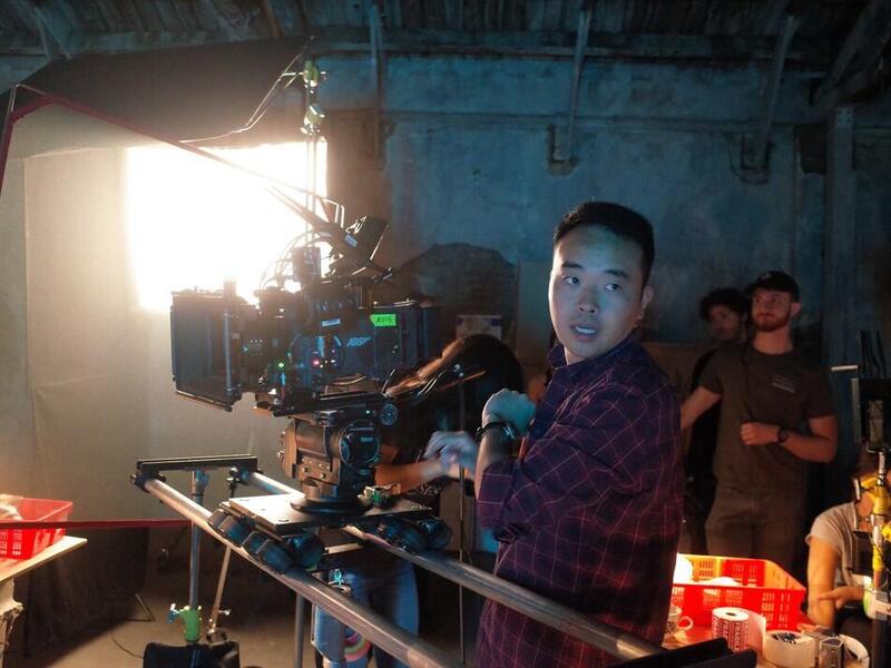A man behind a camera on a filming set 