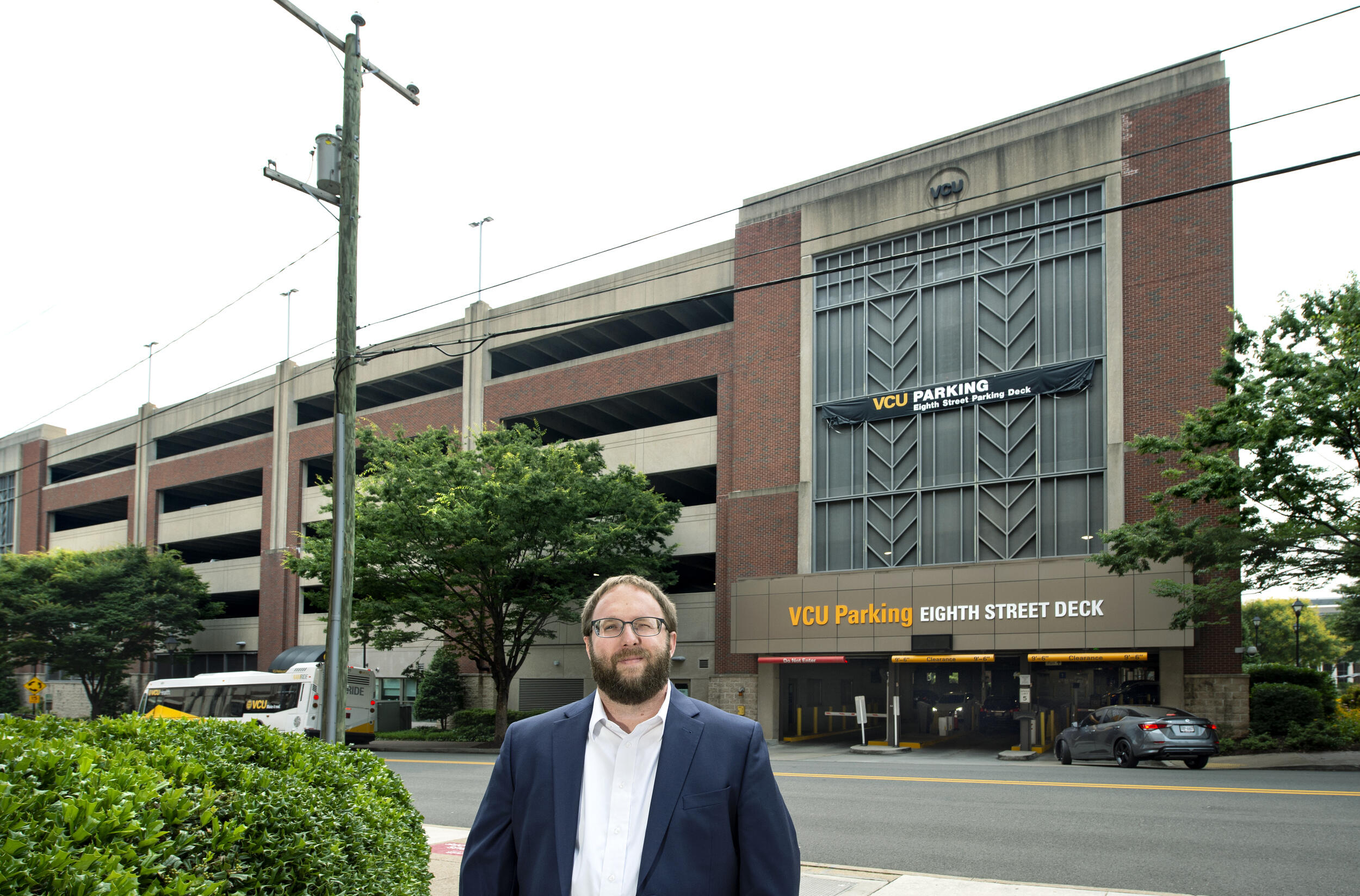 A man standing in front of a parking deck