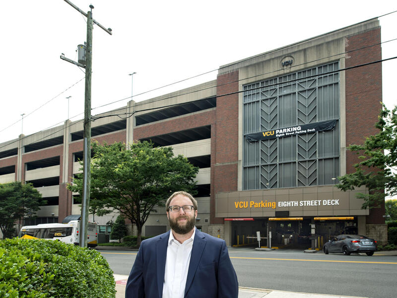 A man standing in front of a parking deck