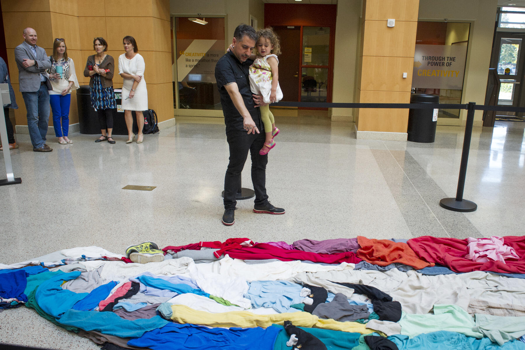 Noah Scalin shows his daughter his latest work in the atrium of Snead Hall. 